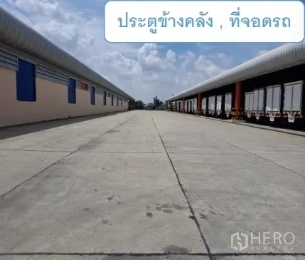 Warehouse for rent in Mueang Pathum Thani, Pathum Thani - Driveway between two warehouses with trailer parking and side gates.