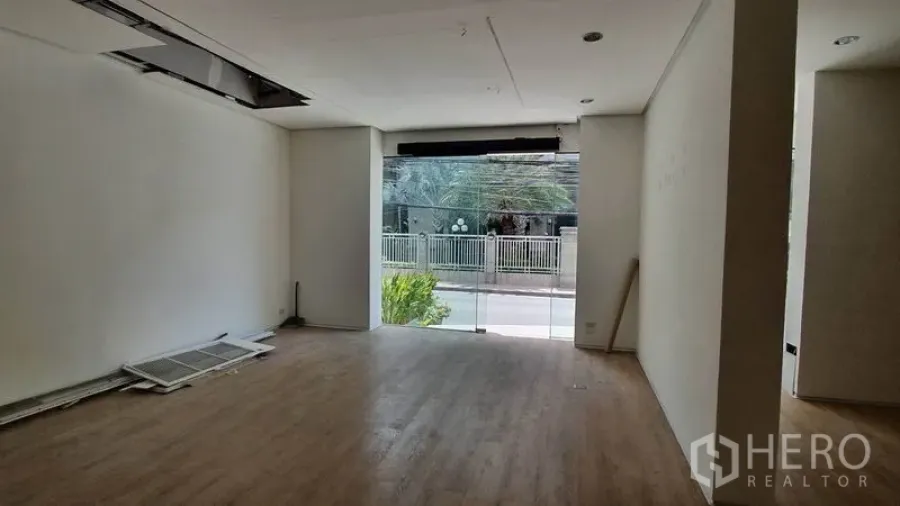Retail Space for rent in Khlong Toei, Bangkok - Bright ground-floor retail interior with wide glass storefront, wood floors and street view.