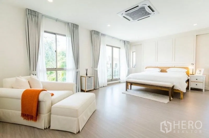 Detached House for rent - Spacious master bedroom with king bed, sofa lounge, large windows, balcony door, and cassette air conditioning.