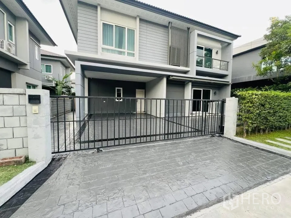 Detached House for rent in Prawet, Bangkok - Modern two-storey house exterior with gated driveway, carport and small lawn.