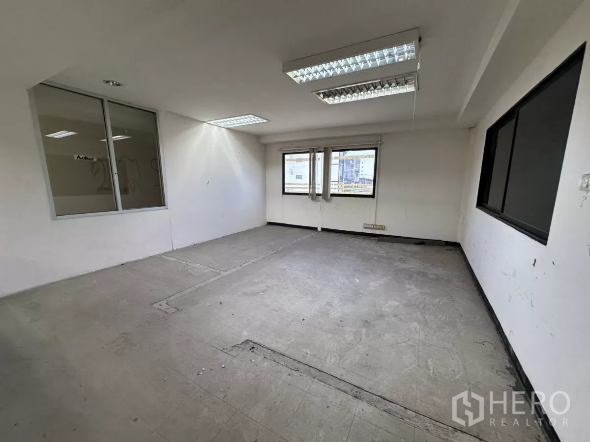 Warehouse for rent in Suan Luang, Bangkok - Small office room featuring multiple windows and an internal glass panel.