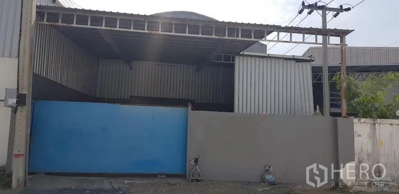 Warehouse for rent in Bang Phli, Samut Prakan - Gated warehouse exterior with wide blue sliding gate and covered entry in Bang Phli.