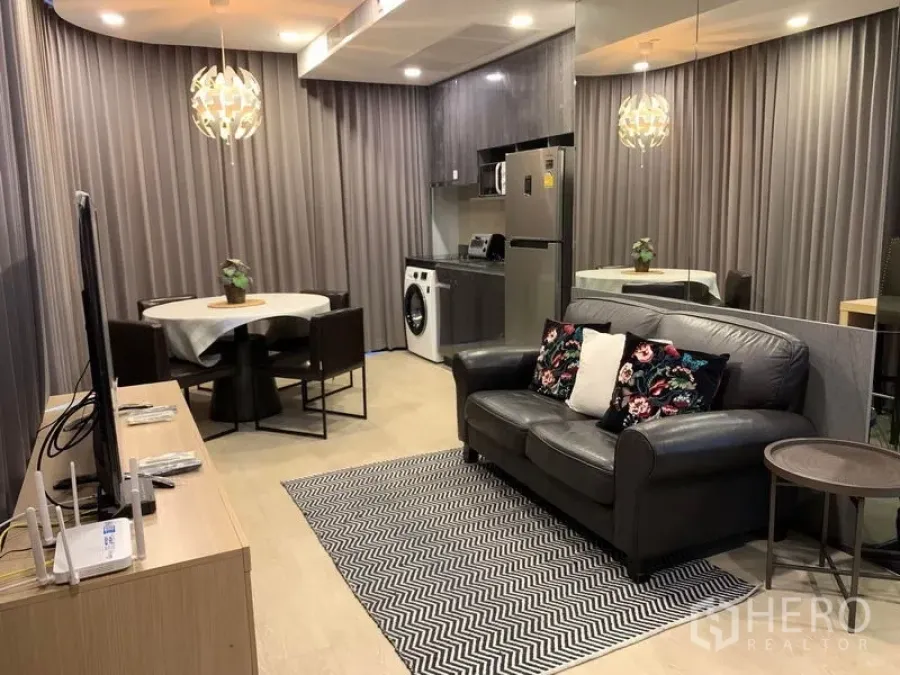 Condominium for rent in Bang Rak, Bangkok - Another angle of the open living area showing sofa, TV console, dining table and kitchenette.