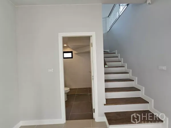 Detached House for sale in Lam Luk Ka, Pathum Thani - Staircase with a bathroom under the stairs and wooden steps.