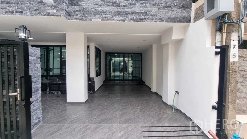 Townhouse for rent in Khlong Toei, Bangkok - Covered forecourt and entrance with tiled floor and pillars, suitable for parking.