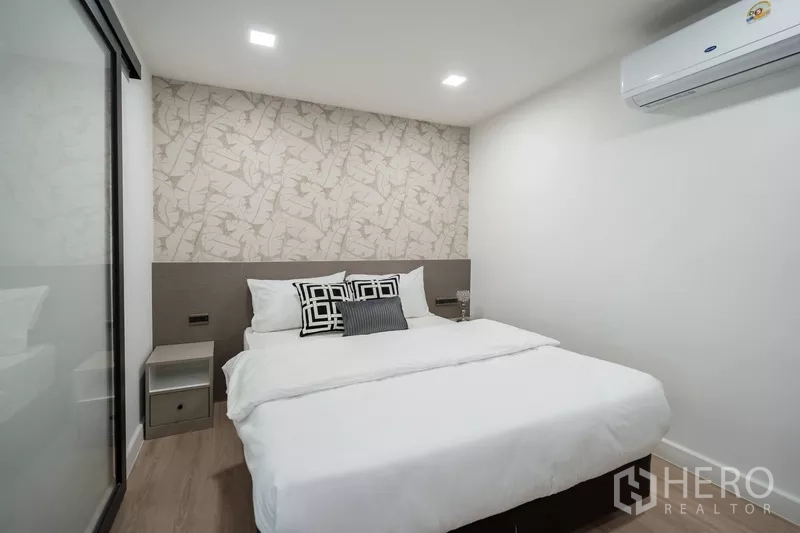 Apartment for rent - Cozy guest bedroom with double bed, feature wall and air conditioning.