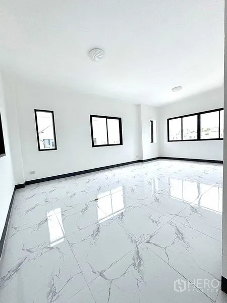 Warehouse for rent in Khlong Luang, Pathum Thani - Spacious open-plan room with multiple black-frame windows and glossy white tiles.