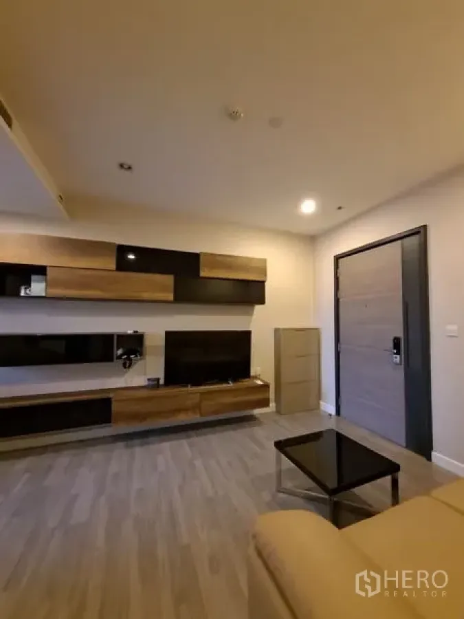 公寓 出租在Bang Rak, Bangkok - 起居区，内置影音墙、茶几与浅木地板。