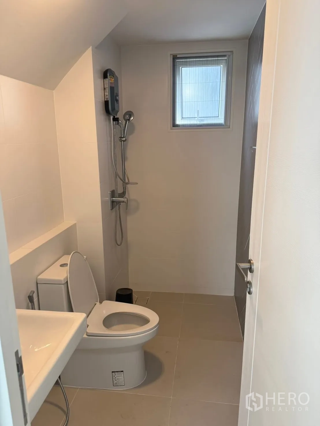 Detached House for rent in Bang Phli, Samut Prakan - Neat bathroom with toilet, sink, and shower with a water heater and small window.
