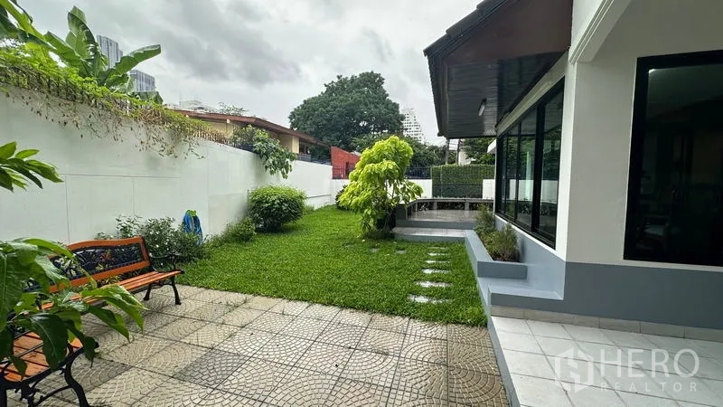 Detached House for rent in Watthana, Bangkok - Private lawn garden with paved patio and bench seating.