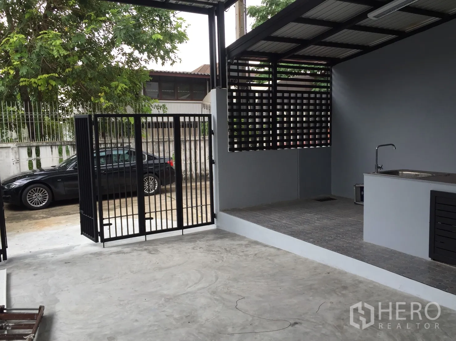 Home Office for rent or sale in Suan Luang, Bangkok - Covered carport with metal gate and an outdoor wet kitchen sink area.
