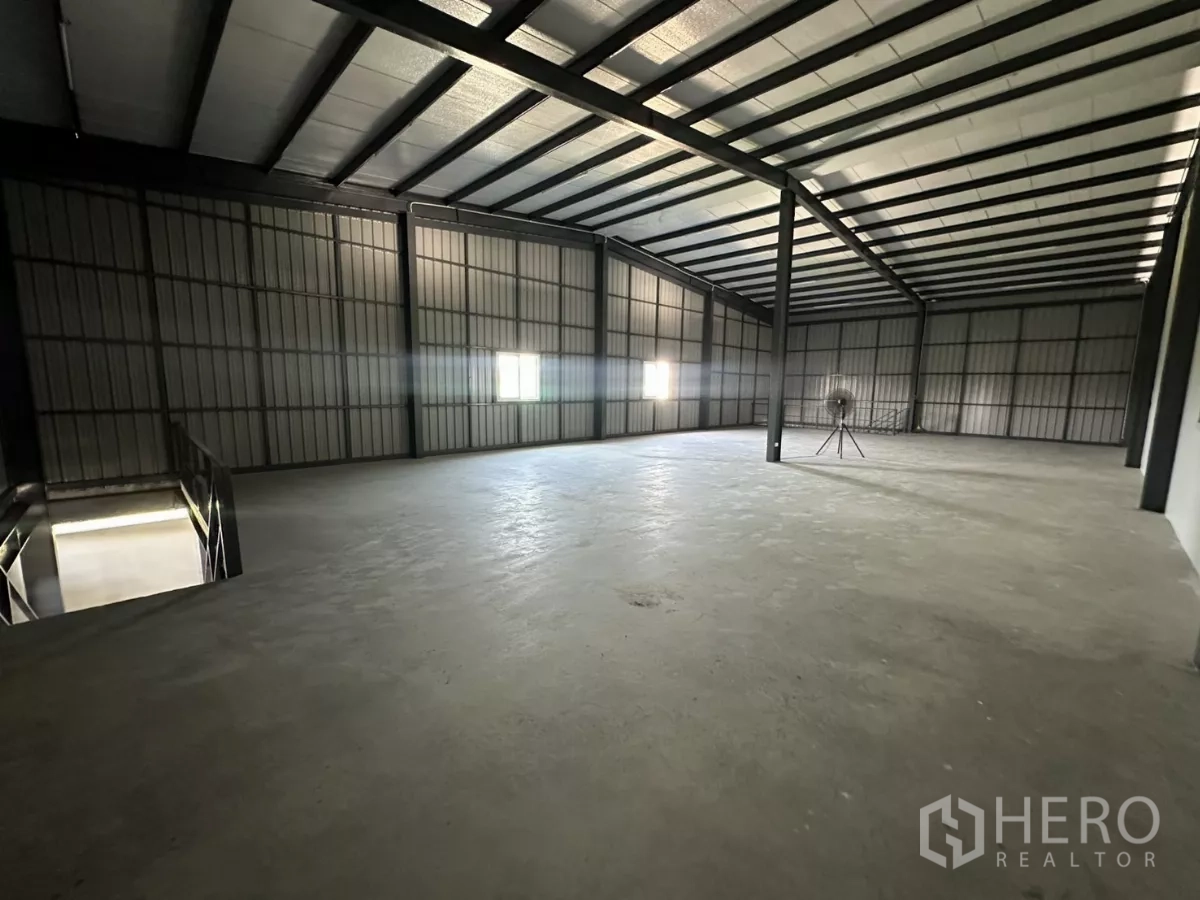 Warehouse for rent in Prawet, Bangkok - Large open-plan mezzanine floor with windows and insulated roof panels.