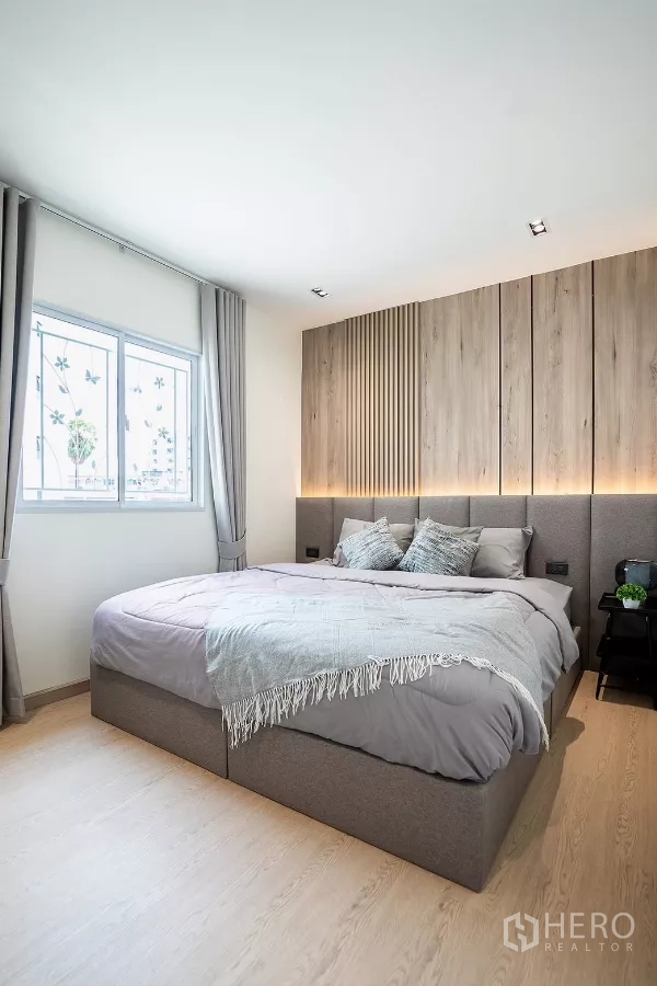 Detached House for rent in Huai Khwang, Bangkok - Master bedroom with wood slat headboard and soft lighting.
