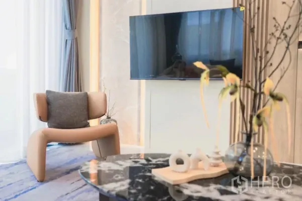 Detached House for rent in Bang Phli, Samut Prakan - Cozy lounge corner with wall-mounted TV, designer armchair and marble coffee table.