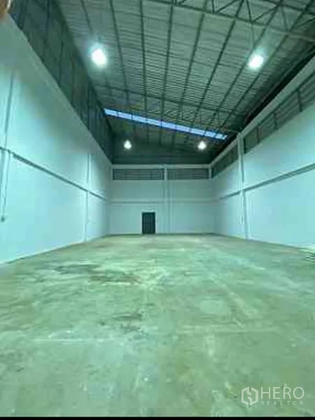 工厂 出租在Mueang Samut Sakhon, Samut Sakhon - 仓库内部空间宽敞，高钢结构屋顶带天窗，干净的混凝土地面。