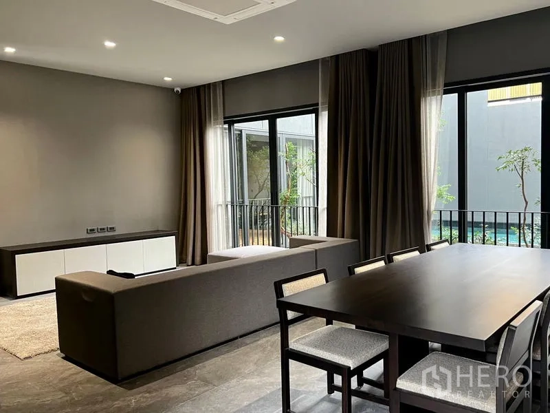 Detached House for rent or sale in Bangkok - Open-plan living and dining area with large windows facing the courtyard.