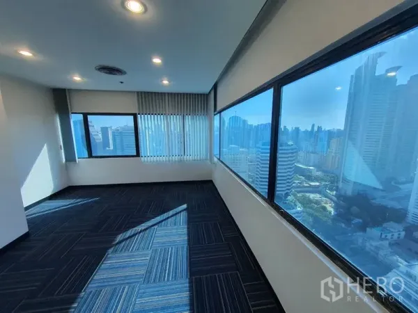 Office Space for rent in Watthana, Bangkok - Corner executive room with floor‑to‑ceiling windows and panoramic skyline view.