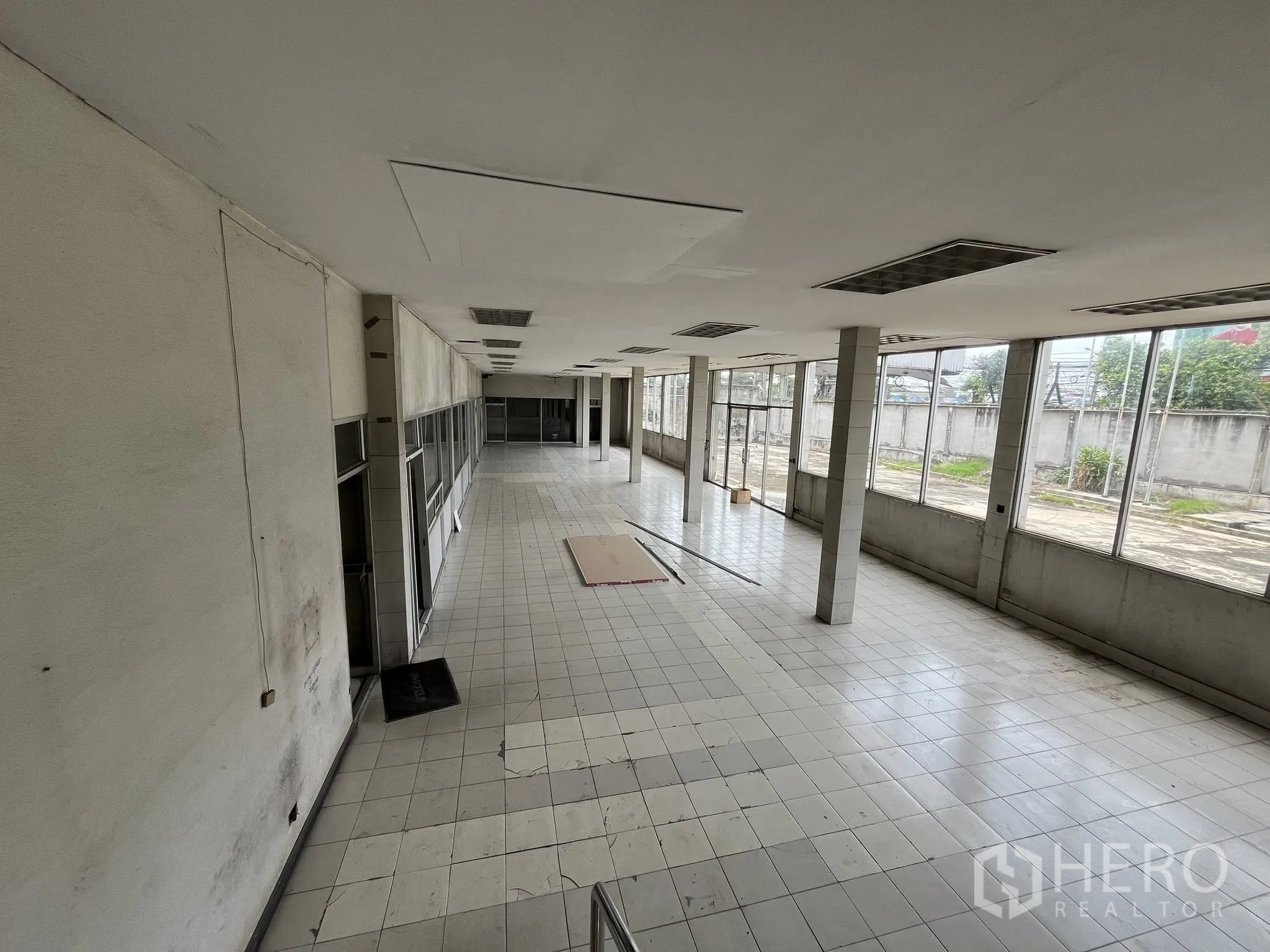 Factory for rent in Phra Pradaeng, Samut Prakan - Bright tiled office or showroom with full-height windows facing the yard.