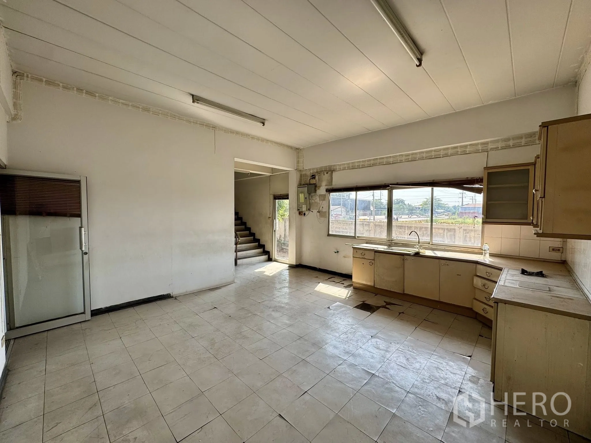 Warehouse for rent in Mueang Samut Sakhon, Samut Sakhon - Ground-floor pantry or break room with L-shaped cabinets and sink beside the staircase.