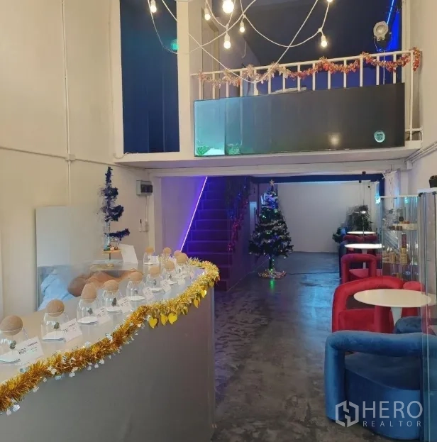Shophouse for rent or sale in Khlong Toei, Bangkok - Display counter with glass jars, string lights, seating area and a mezzanine above.