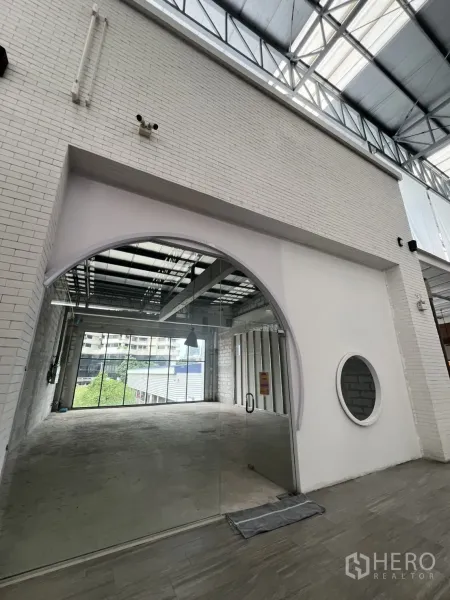 Retail Space for rent - Wide view of arched glass storefront set under a skylit atrium with tiled walkway.
