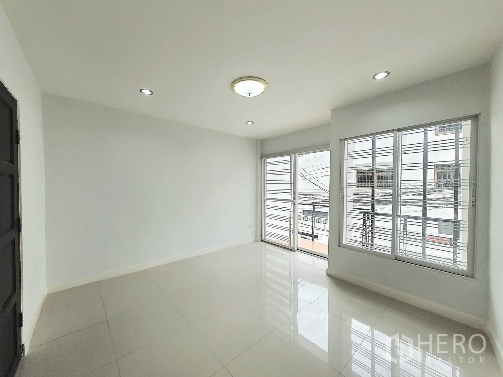 带办公室的家 出租在Khlong Toei, Bangkok - 卧室带转角大窗与阳台推拉门，配防护栏。