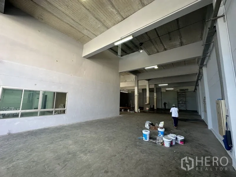 Factory for rent or sale in Bang Bua Thong, Nonthaburi - High-ceiling production hall with concrete floor and internal office observation window.