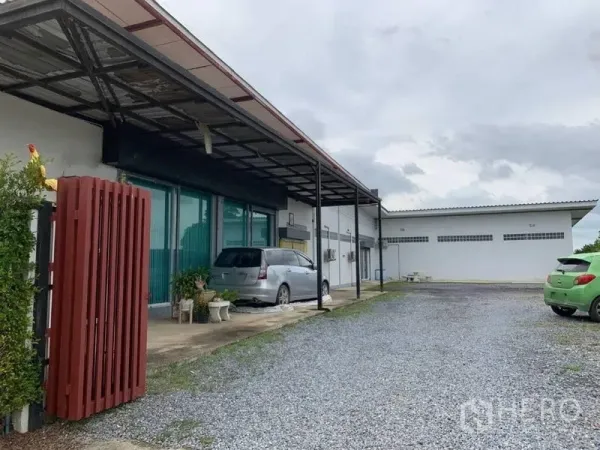 Factory for sale in Bang Pa-in, Phra Nakhon Si Ayutthaya - Low-rise factory exterior with a covered loading bay, glass-front office and gravel parking area.