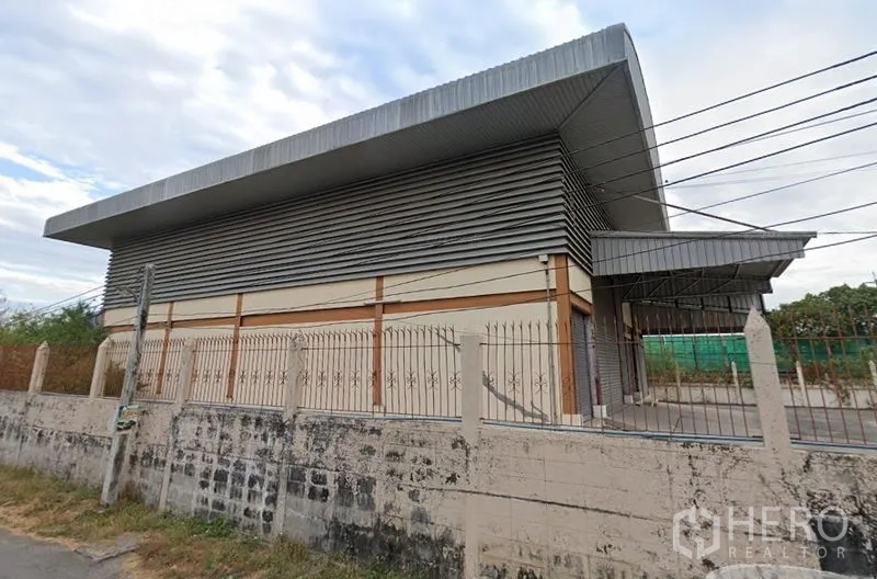 Warehouse for rent in Bang Phli, Samut Prakan - Street view of a metal-clad warehouse with a high roof and perimeter fence in Bang Phli.