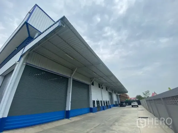 货栈 出租在Pathum Thani - 仓库侧立面，长雨棚和宽敞卡车回转空间。