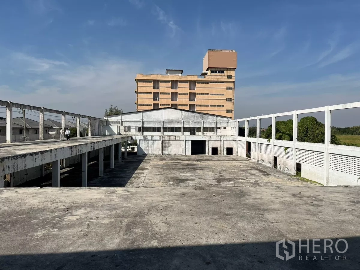 工厂 出售在Bang Phli, Samut Prakan - 宽阔的上层混凝土平台与中央仓库庭院，背景为办公楼。