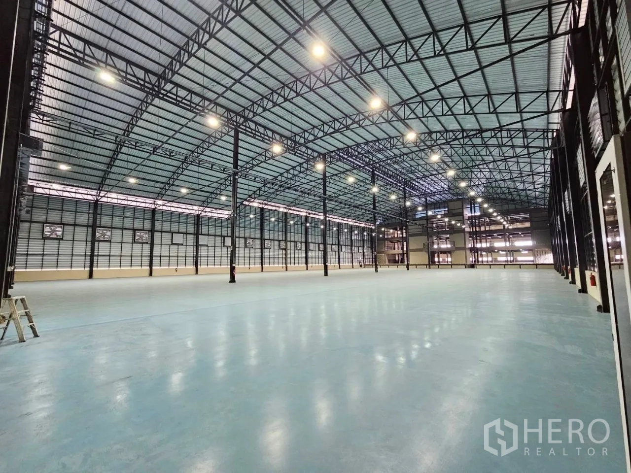 Factory for rent in Si Racha, Chon Buri - Expansive factory hall with high steel truss roof and polished heavy-duty floor.