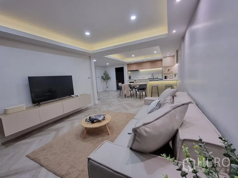 Townhouse for rent or sale - Open-plan lounge view facing the illuminated kitchen and dining island.