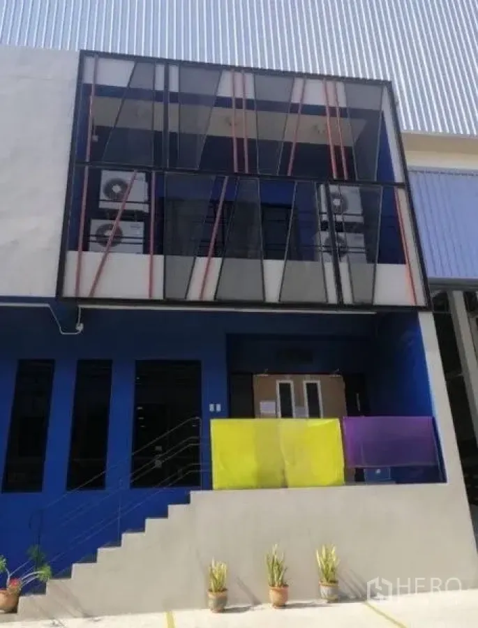 Warehouse for rent in Bang Phli, Samut Prakan - Close-up of the glass-front office facade with stairs and potted plants.