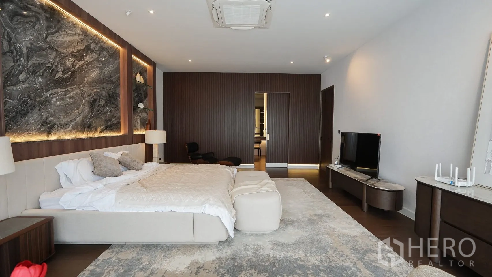 Detached House for rent or sale in Bang Kapi, Bangkok - Master bedroom showing TV console, large windows and soft neutral decor.