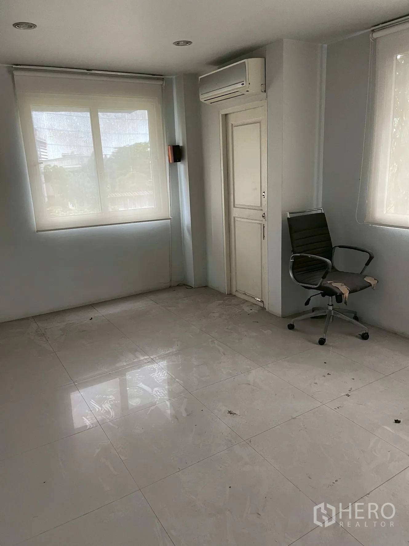 Home Office for rent in Wang Thonglang, Bangkok - Corner office with windows on two sides, air conditioner and glossy tile floor.