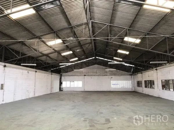 货栈 出租在Mueang Pathum Thani, Pathum Thani - 开放式仓库大厅广角视图，三角形高屋顶、吊灯和多扇窗户，通风良好。