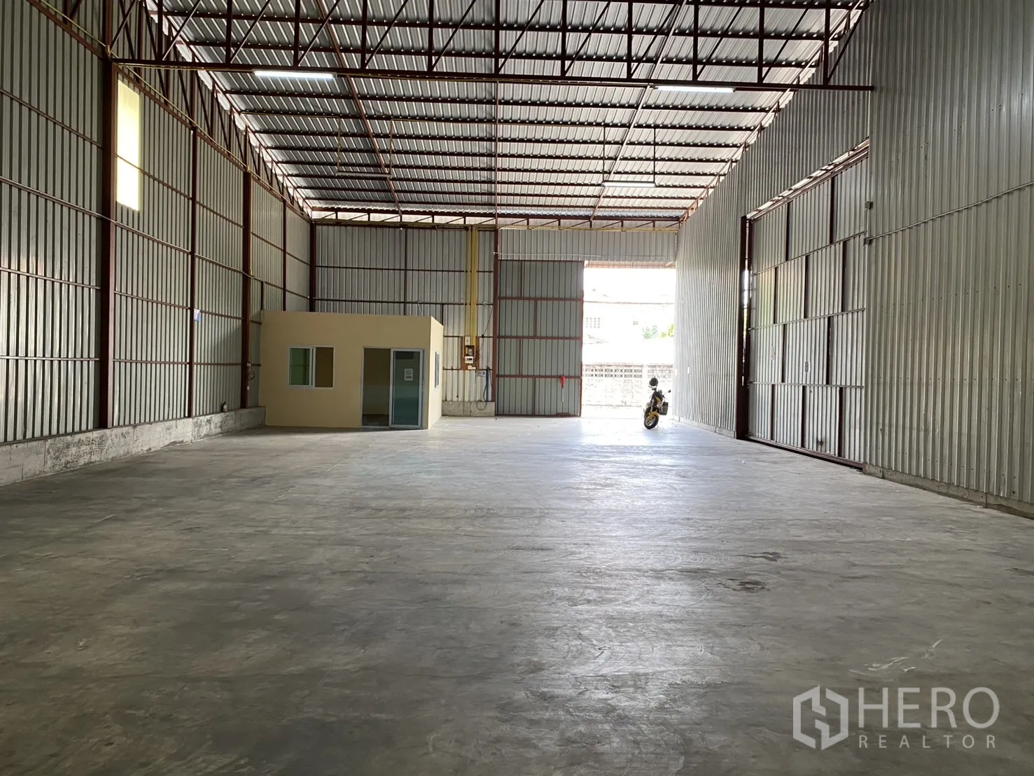 仓库 for rent in Bueng Kum, Bangkok - 仓库远景，可见宽装卸入口与室内办公室。