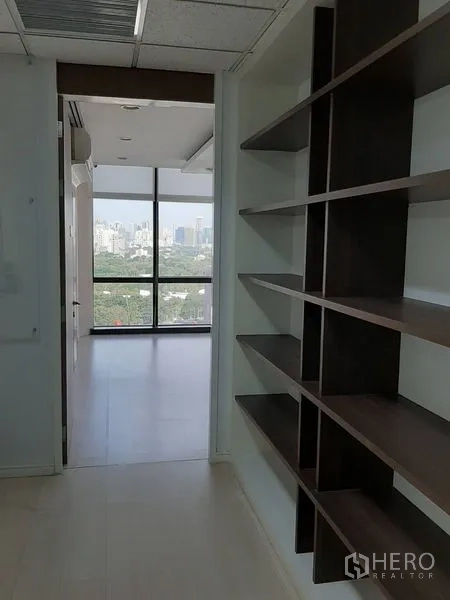 Office Space for rent in Bang Rak, Bangkok - Storage-lined hallway opening to a bright office with full-height windows.