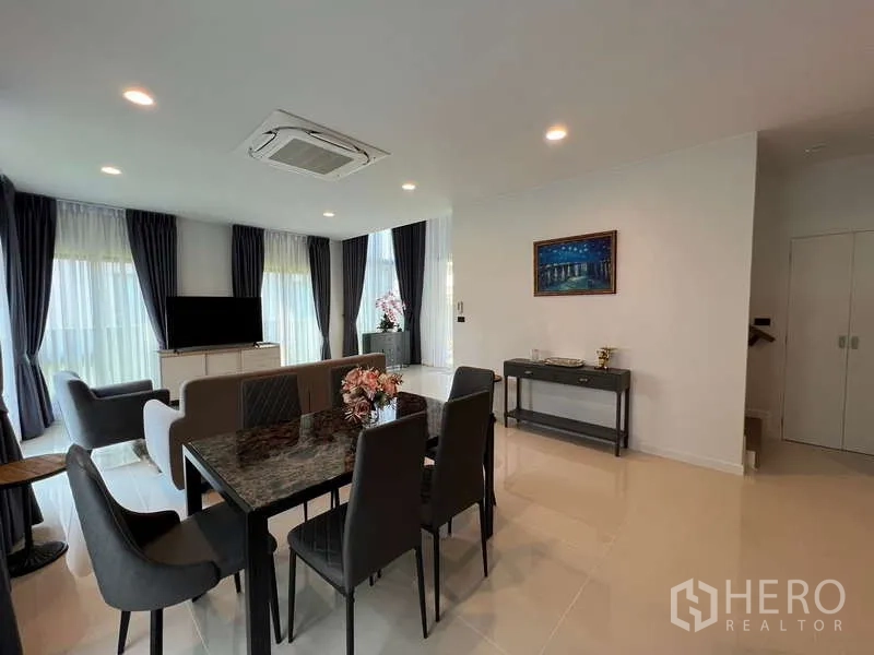 Detached House for rent in Bang Kapi, Bangkok - Dining space connected to living area with recessed lights and staircase.