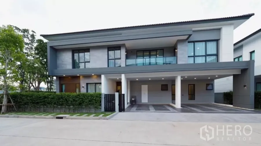 Detached House for rent in Bang Phli, Samut Prakan - Modern two-storey detached house exterior at The City Bangna with balcony and covered carport.