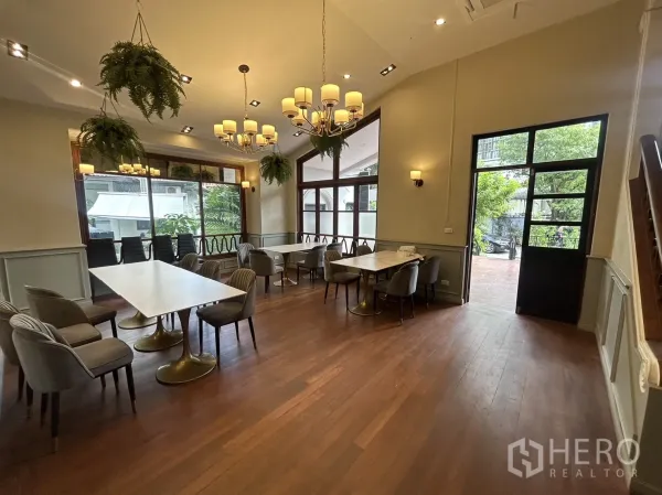 Retail Space for rent in Bangkok - Bright dining-style retail hall with chandeliers, large windows, wood floors and marble tables.