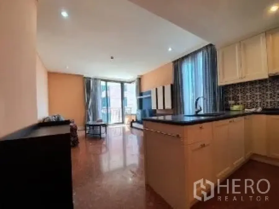 Condominium for sale - View from the kitchen toward the living room and balcony filled with daylight.