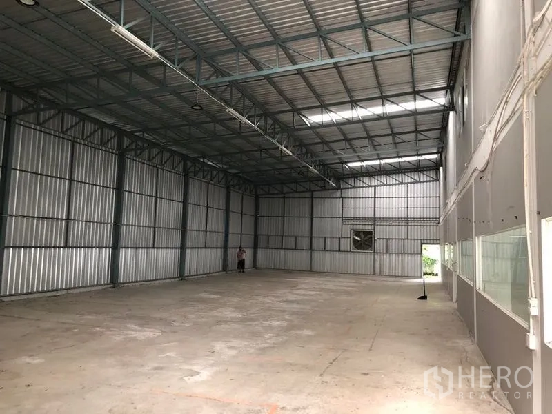 货栈 出租在Khlong Sam Wa, Bangkok - 深进式仓库通道，金属墙板、屋顶采光带与混凝土地面。