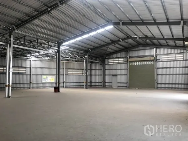 货栈 出租在Bang Yai, Nonthaburi - 仓库内部空间高挑，钢结构山墙屋顶，采光带与混凝土地面。