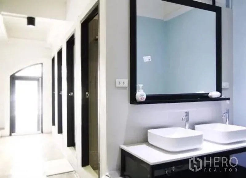 Retail Space for rent in Khlong Toei, Bangkok - Shared bathroom vanity with twin vessel sinks and a large framed mirror.