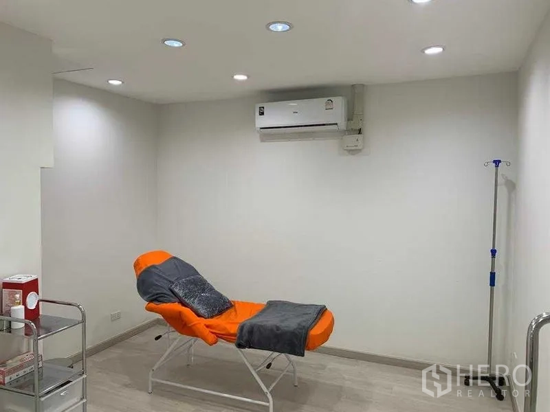 Retail Space for rent in Pathum Wan, Bangkok - Minimal treatment room with an orange recliner, white walls and recessed ceiling lights.