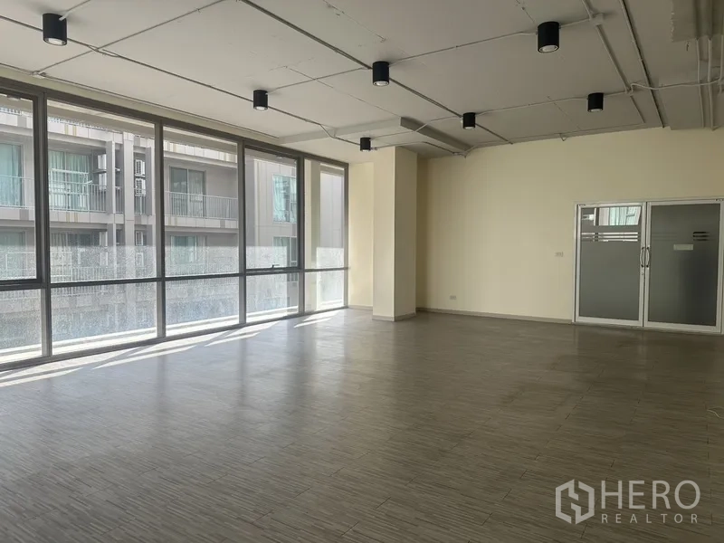 Office Space for rent in Phra Khanong, Bangkok - Sunlit office area featuring full-height glazing and frosted double doors, ready for fit-out.