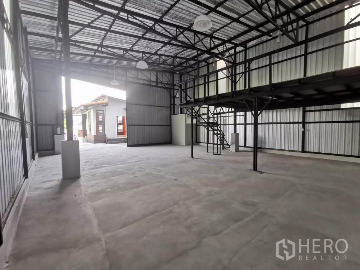 Warehouse for rent in Khlong Toei, Bangkok - High-ceiling steel-frame warehouse interior with mezzanine and large loading door.