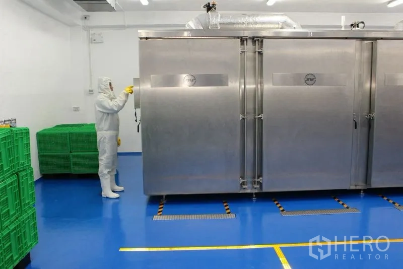 Factory for rent or sale in Krathum Baen, Samut Sakhon - Clean processing room with a large stainless industrial chamber and blue epoxy floor.